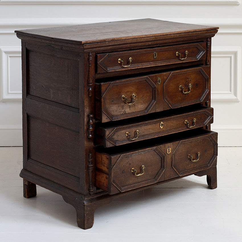 Wooden dresser with multiple drawers against a white wall