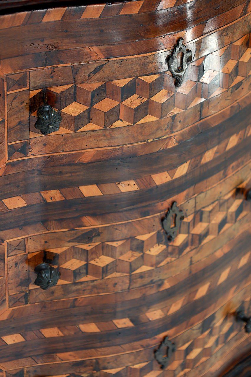 Close-up of a wooden chest with geometric pattern and metal handles