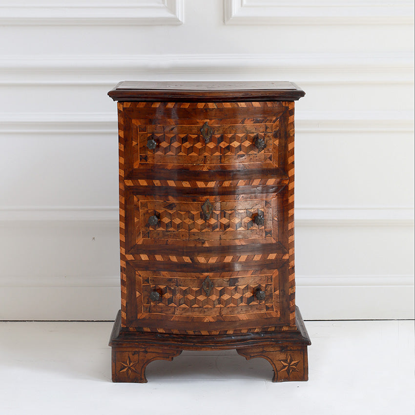 Wooden chest of drawers with intricate patterns on a white background