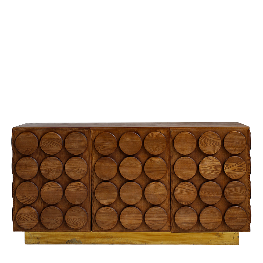 A mid-century modern wooden sideboard featuring three panels of circular wood cutouts, finished in a warm medium brown wood tone with a light natural wood base, shown against a plain white background.