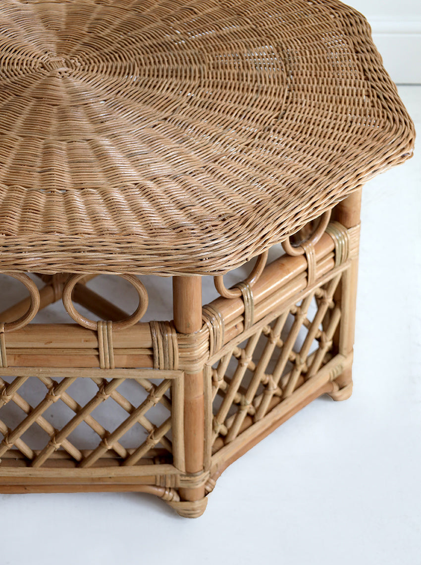 Wicker side table with a textured surface on a white background