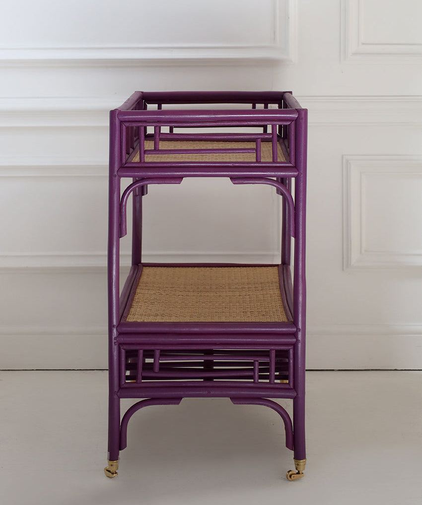 Purple rattan cart with woven top against a white wall