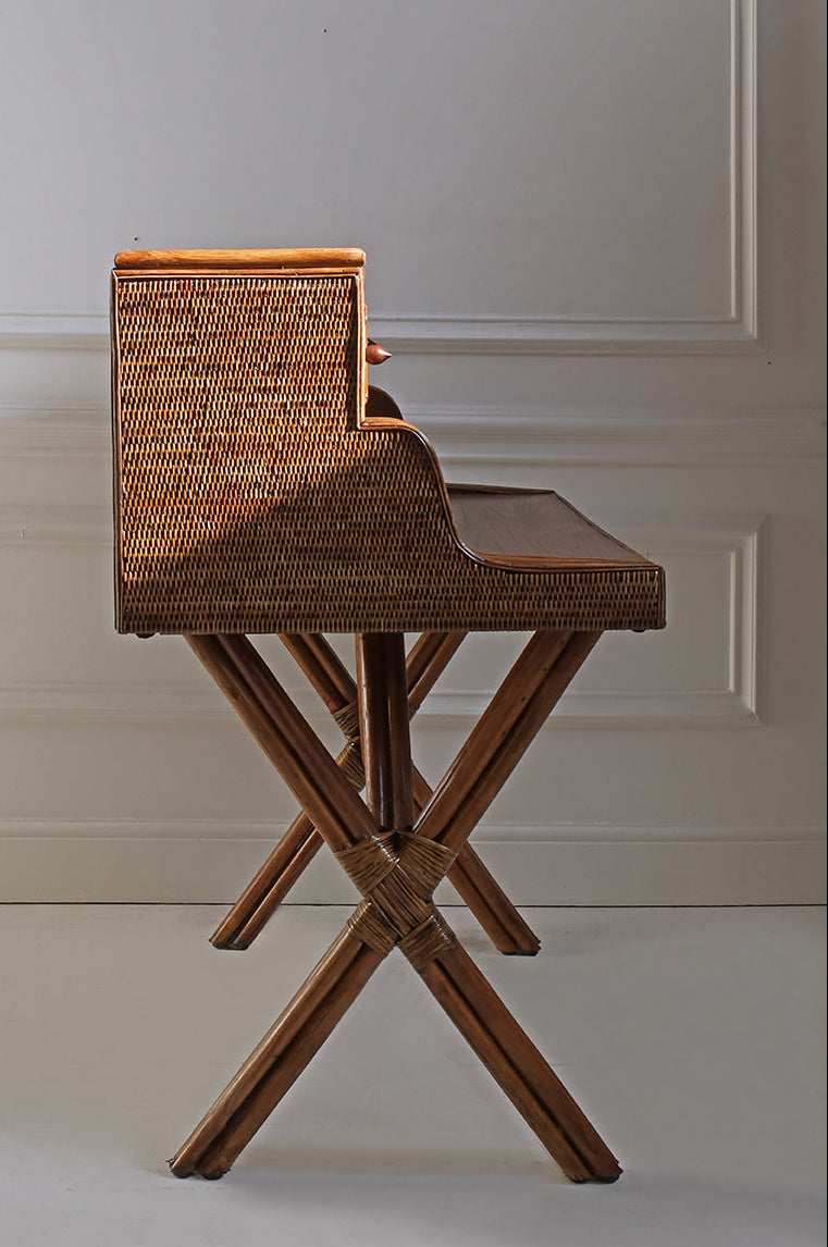 Wicker bar stool with a wooden seat against a neutral wall.