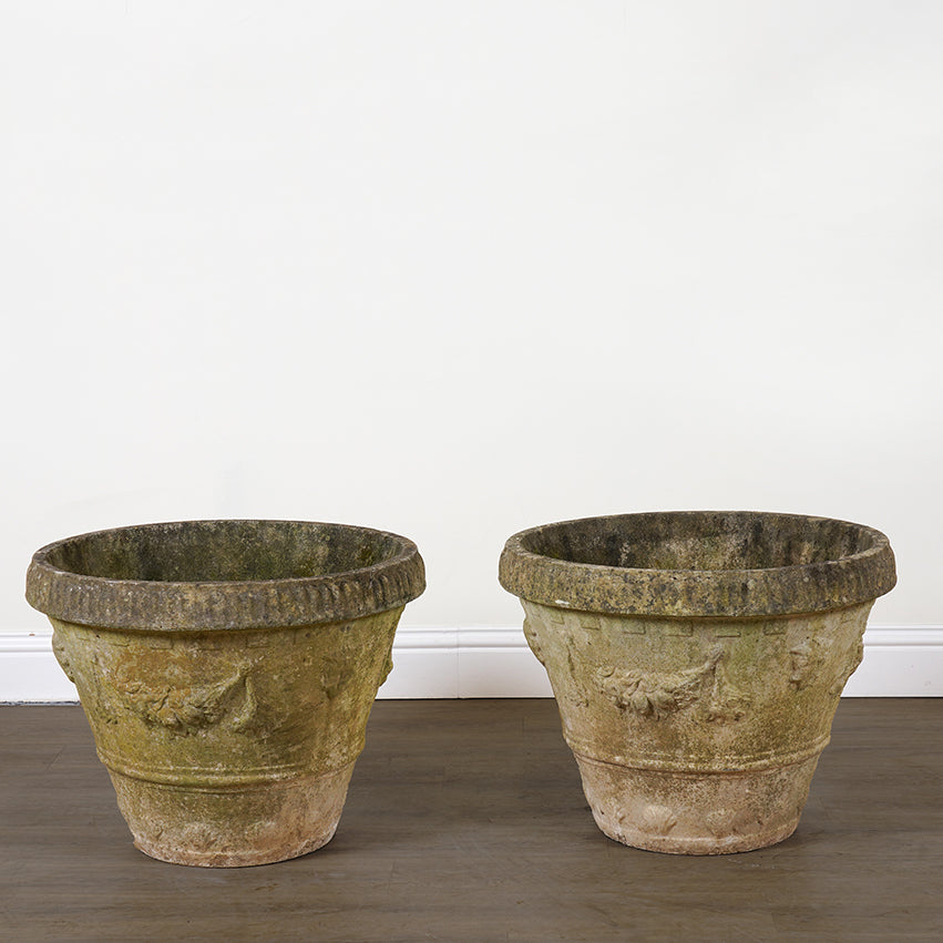 Two vintage-style stone planters on a plain background