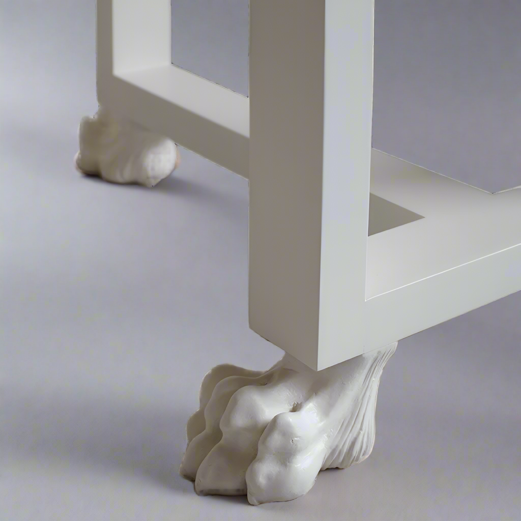 White furniture leg with decorative paw-like design on a light gray background