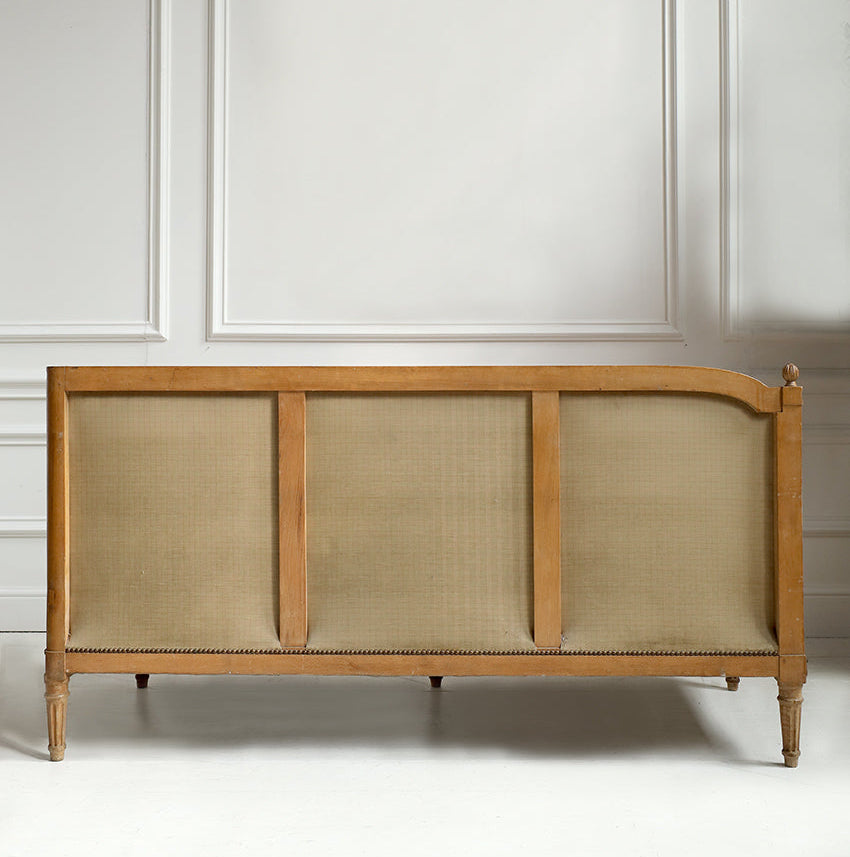 Wooden sideboard with woven design against a white paneled wall