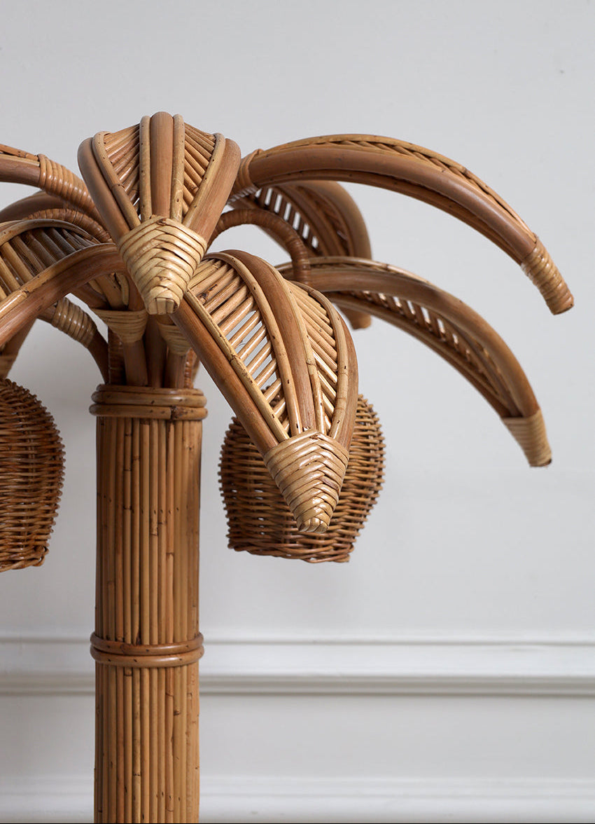 Rattan palm tree lamp against a white wall