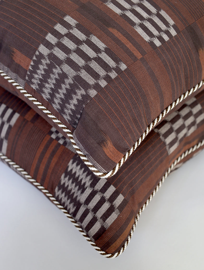 Stack of patterned fabric cushions on a light gray background