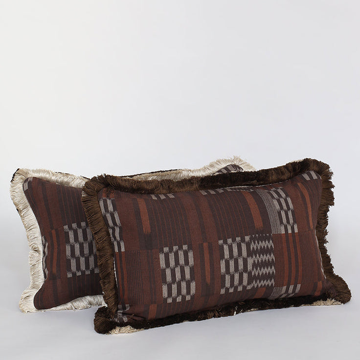 Two decorative pillows with tribal patterns on a light gray background