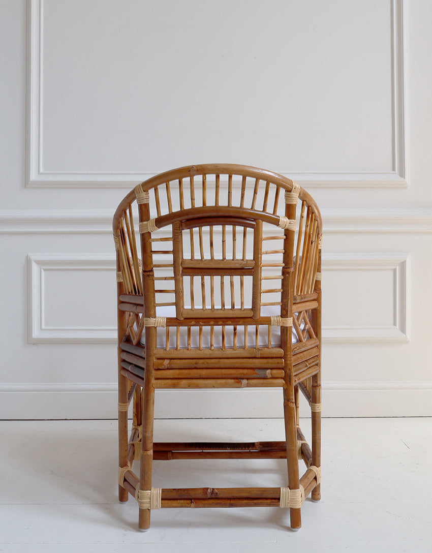 Rattan chair against a white paneled wall