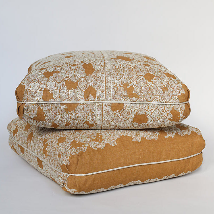 Two patterned cushions stacked on a light gray background