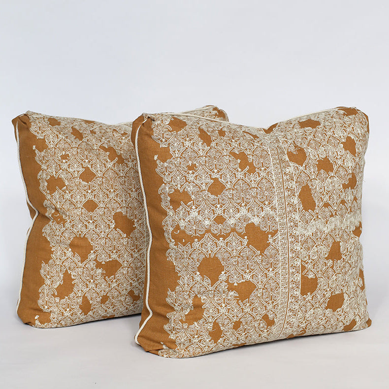 Two decorative pillows with brown and beige pattern on a white background