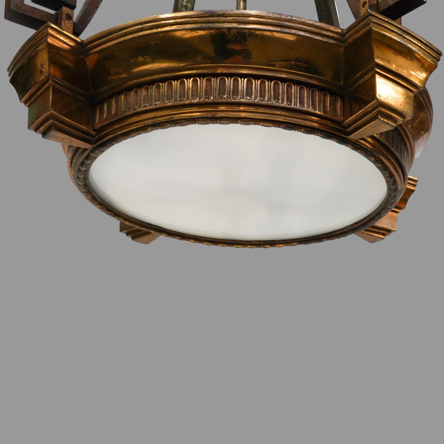 Decorative ceiling light fixture with gold frame and white glass on a white background