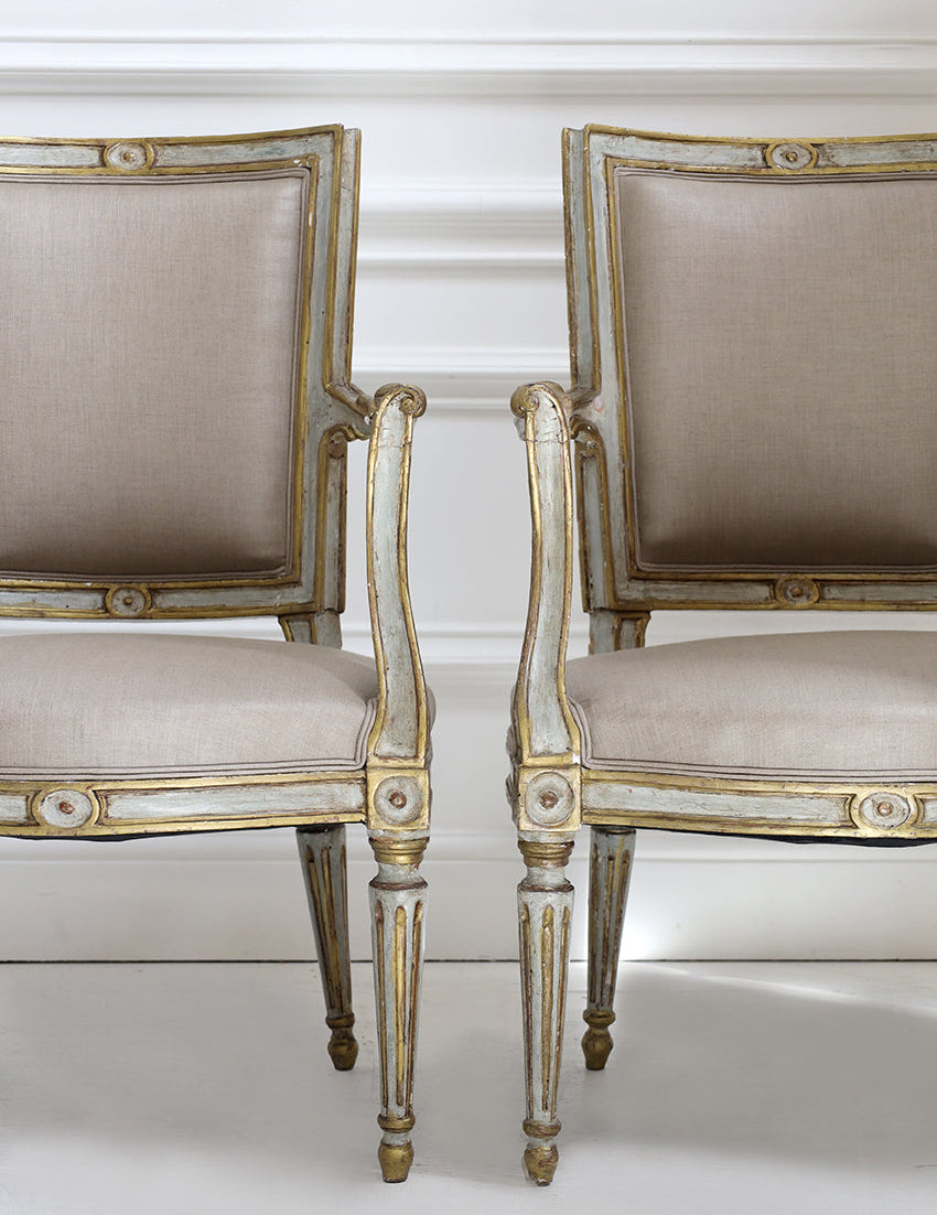 Pair of ornate chairs with gold accents on a white background