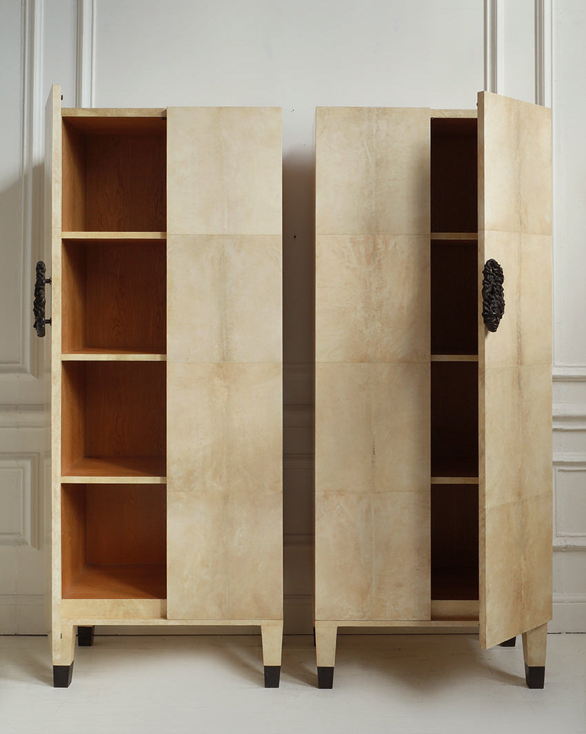 Wooden cabinet with open doors on a white floor and light-colored wall background