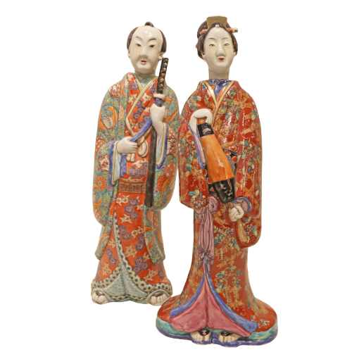 Two ceramic figurines in traditional attire on a white background