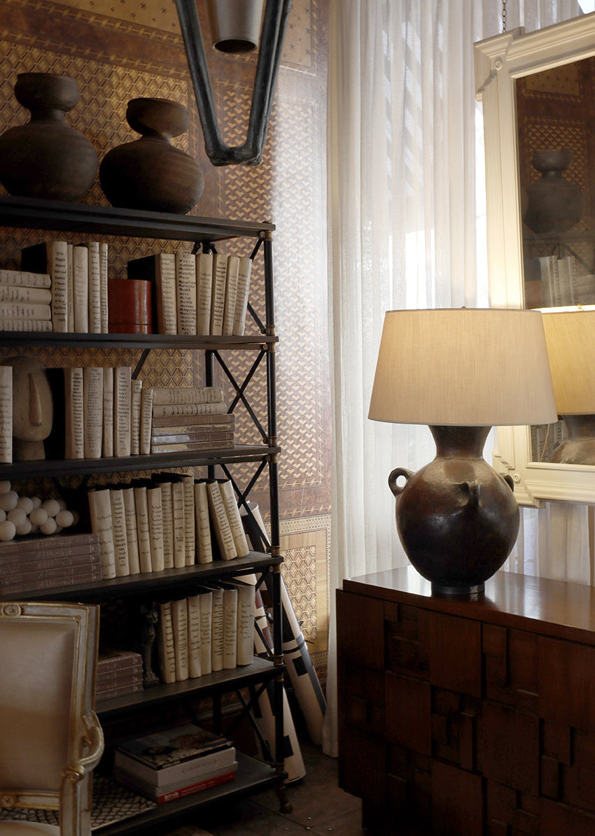 Room interior with bookshelf, lamp, and decorative items.