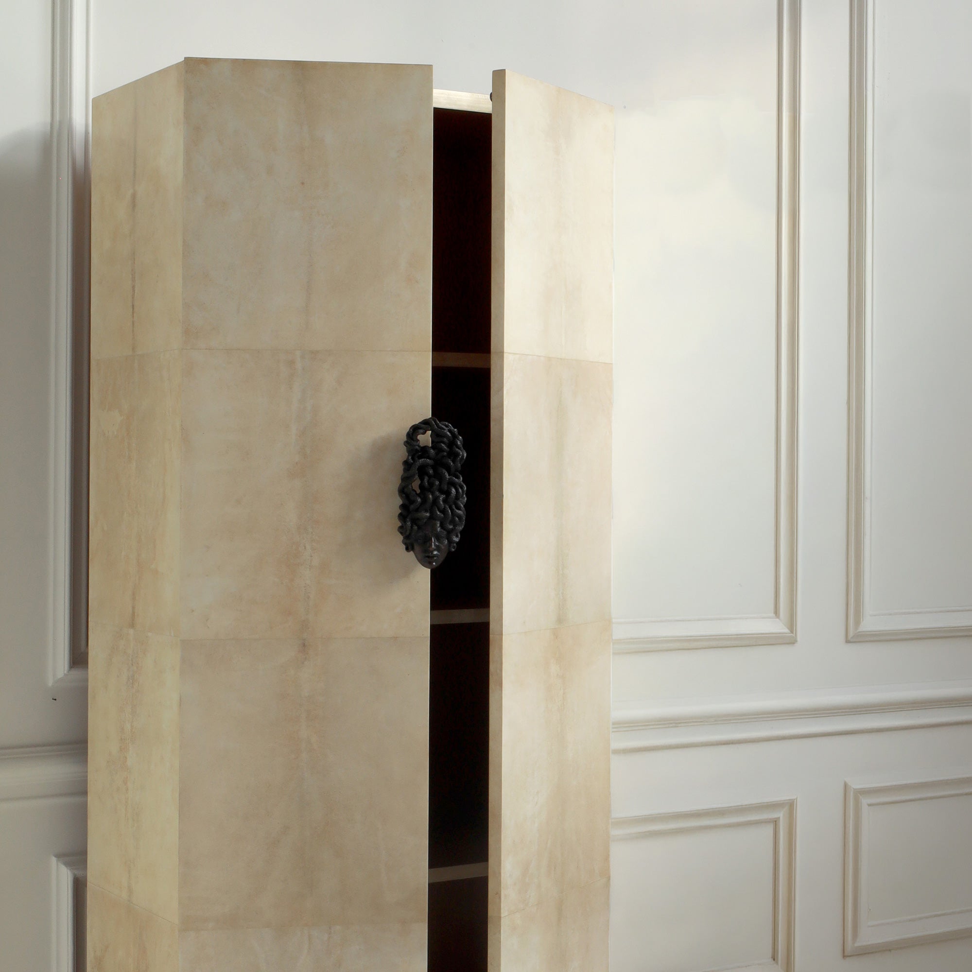 Beige wardrobe with open door in a room with white paneled walls.