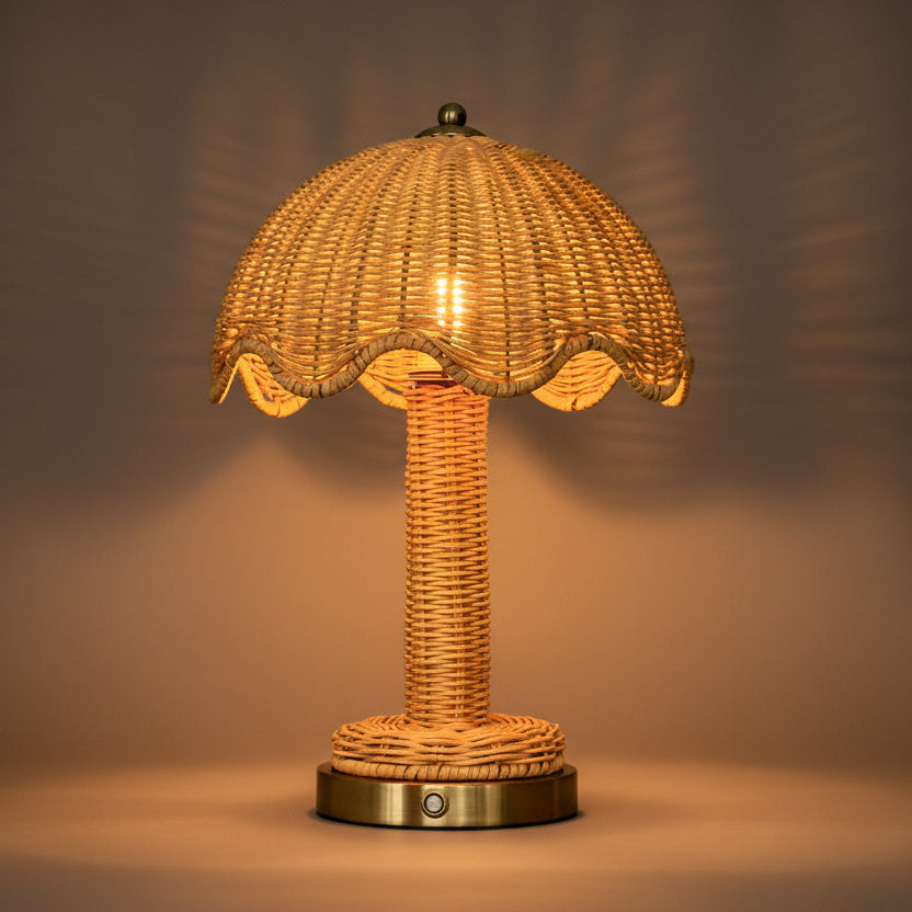 Wicker table lamp with scalloped shade on a neutral background