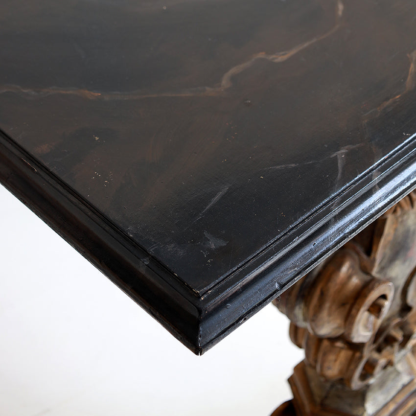 Close-up of a dark wooden surface with intricate carvings on a white background