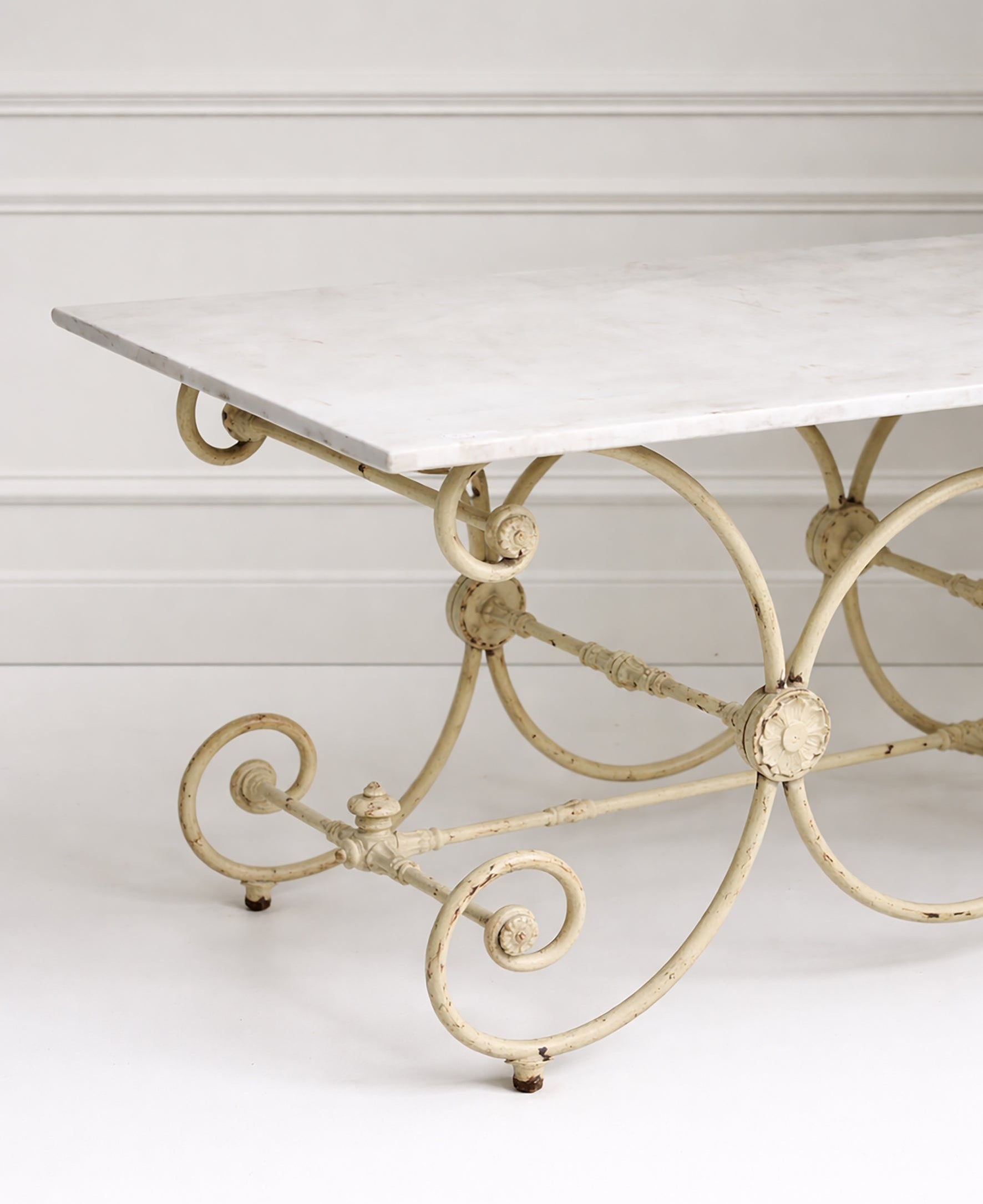 Decorative metal table base with marble top on a white background