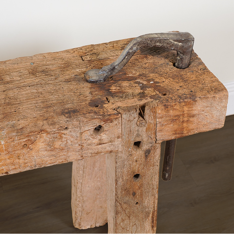 Old wooden anvil with a metal handle on a white background