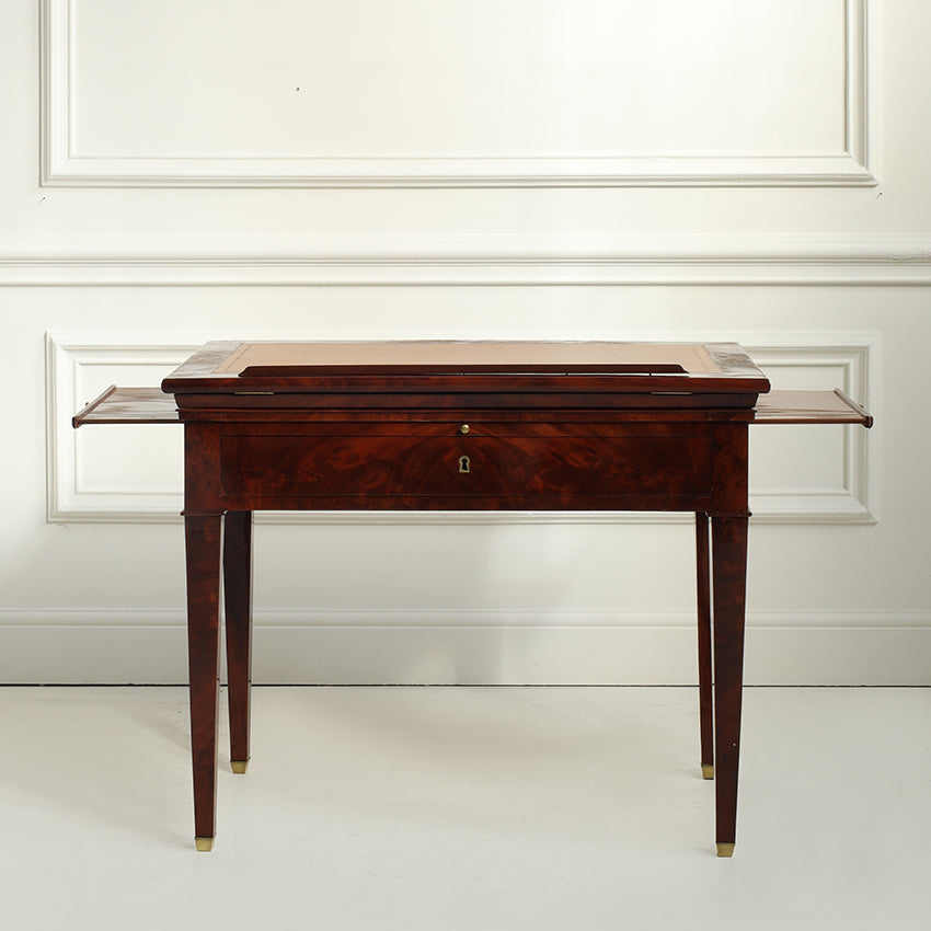 Wooden desk with a drawer against a white wall