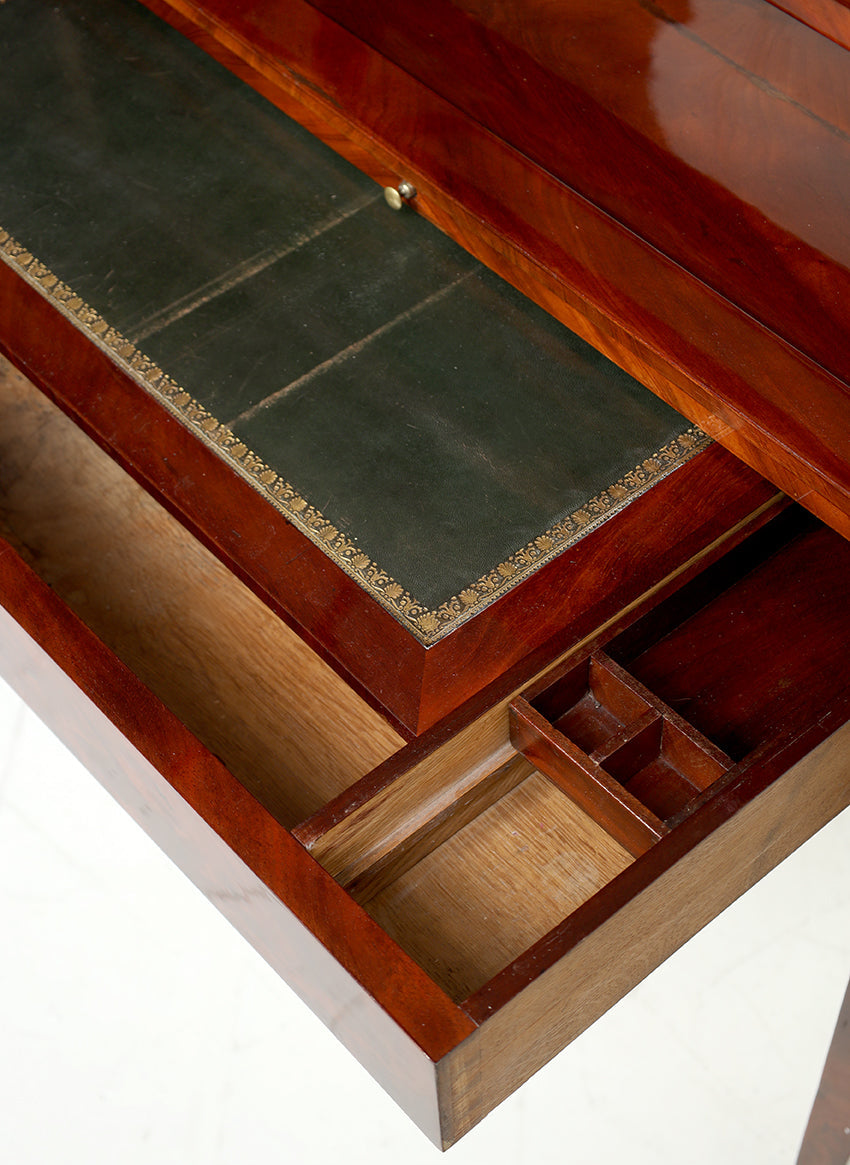 Wooden desk with a green leather writing surface on a white background