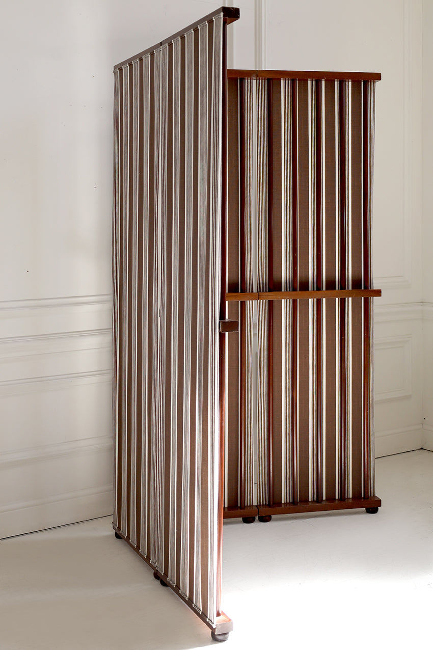 Wooden bookshelf with striped design against a white wall