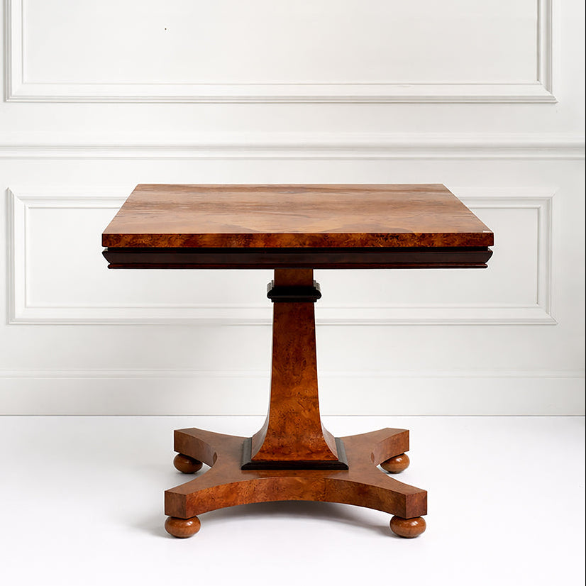 Biedermeier Wooden table with a pedestal base against a white paneled wall