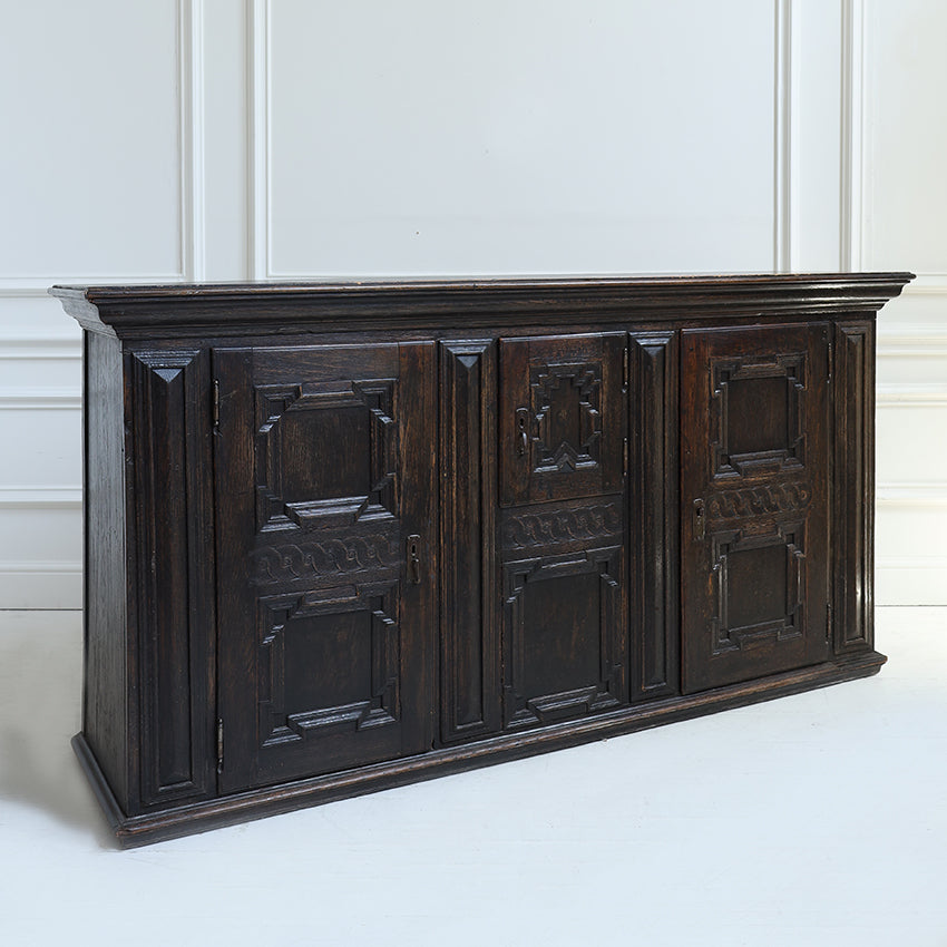 Dark wooden sideboard with decorative panels on a white background