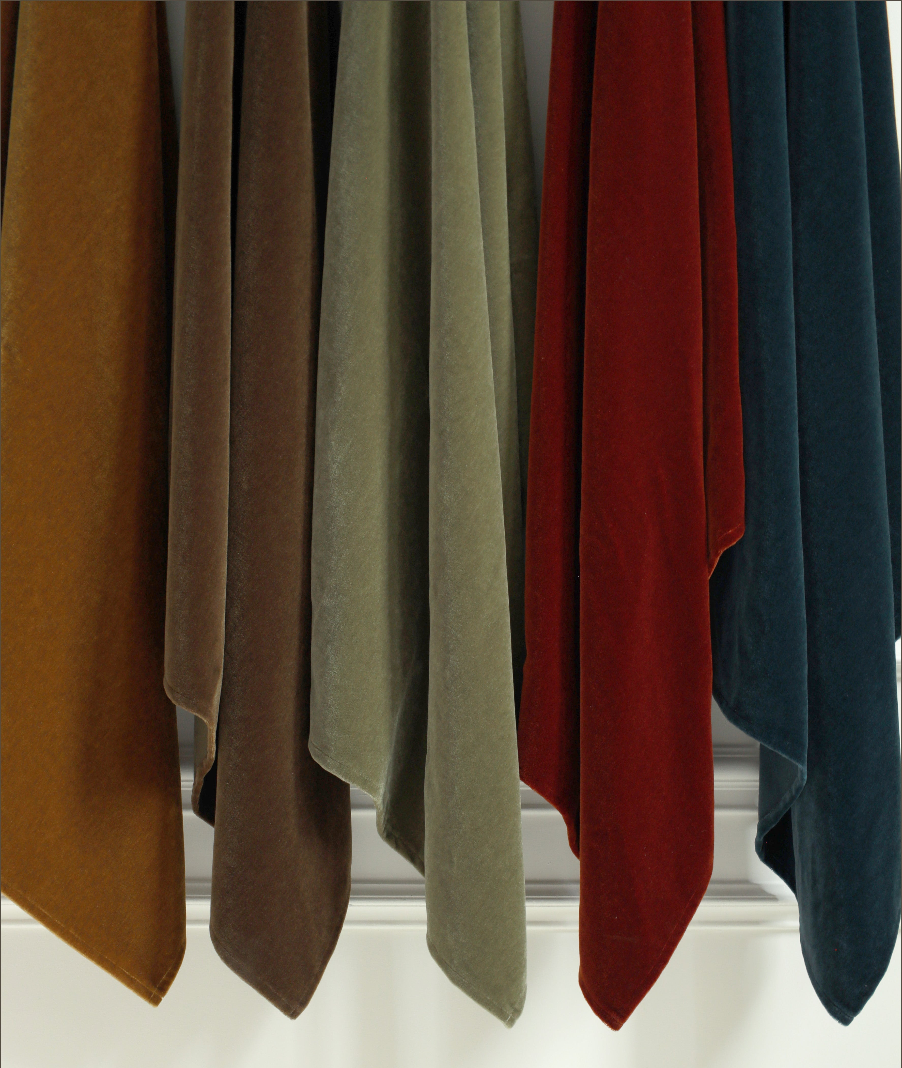 Set of colorful scarves hanging against a white background