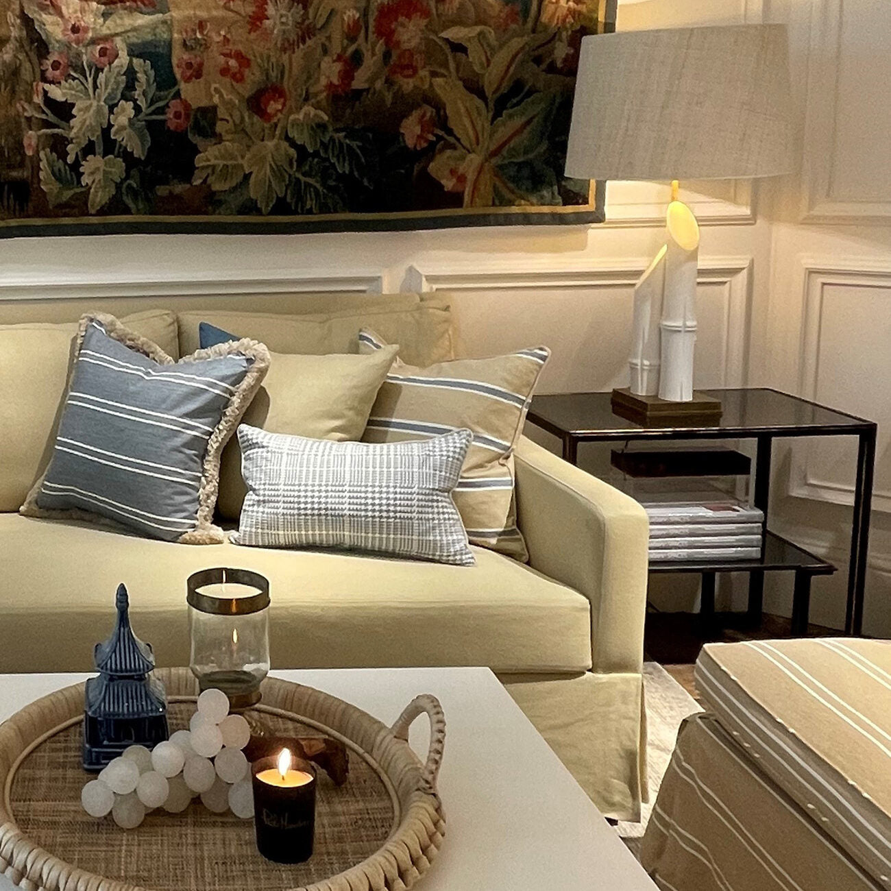 Living room with beige sofa, decorative pillows, and a coffee table with candles and decor items.