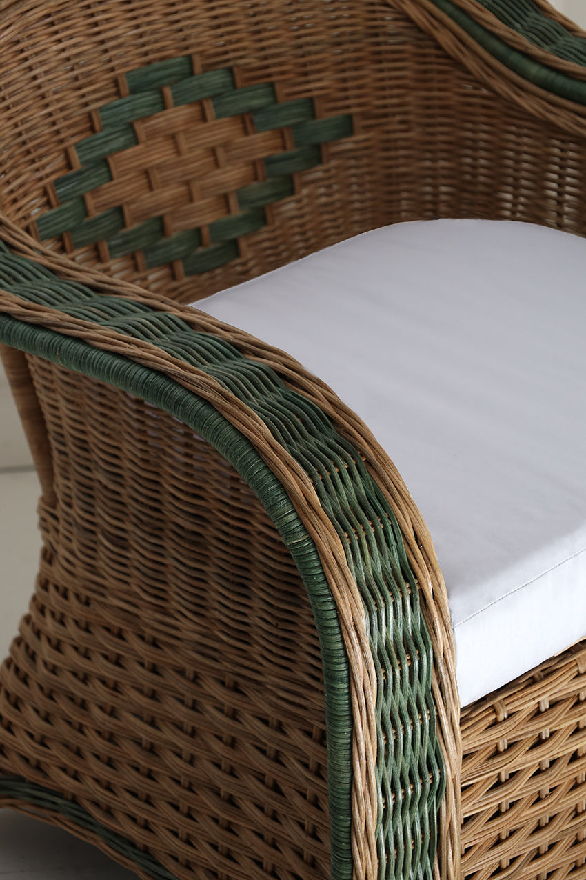 Close-up of a wicker chair with a white cushion