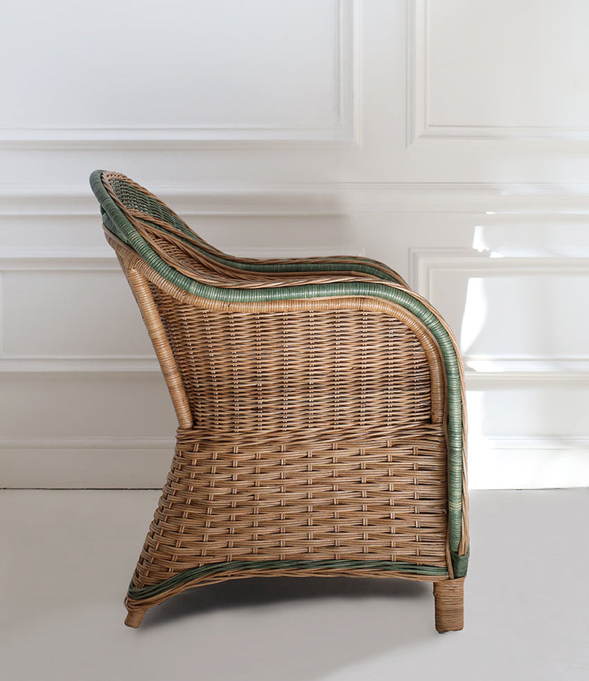 handcrafted wicker chair with green trim on a white background