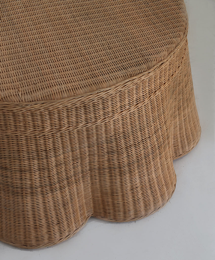 Close-up of a handwoven brown ottoman on a light gray background