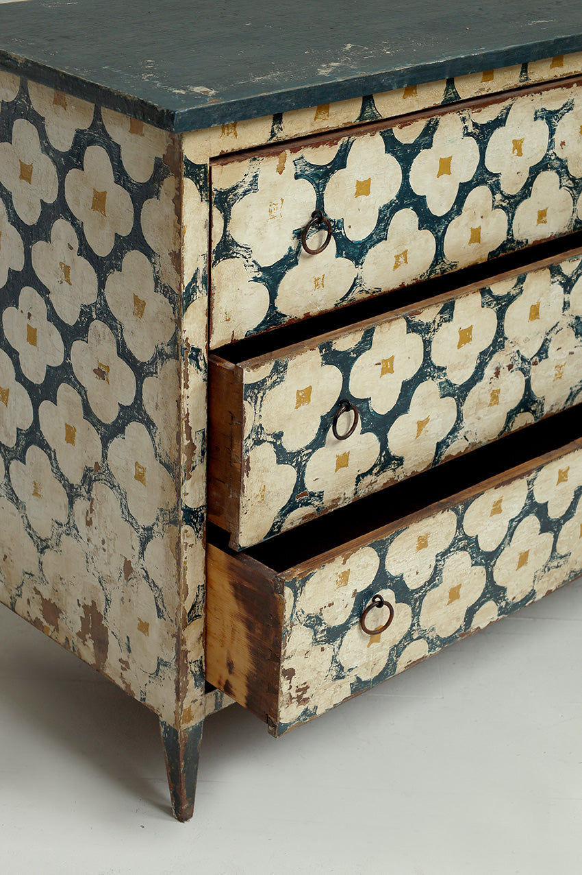 Vintage dresser with floral patterned side panels on a plain background