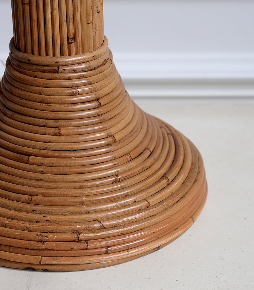 Close-up of a woven rattan base on a light-colored floor.
