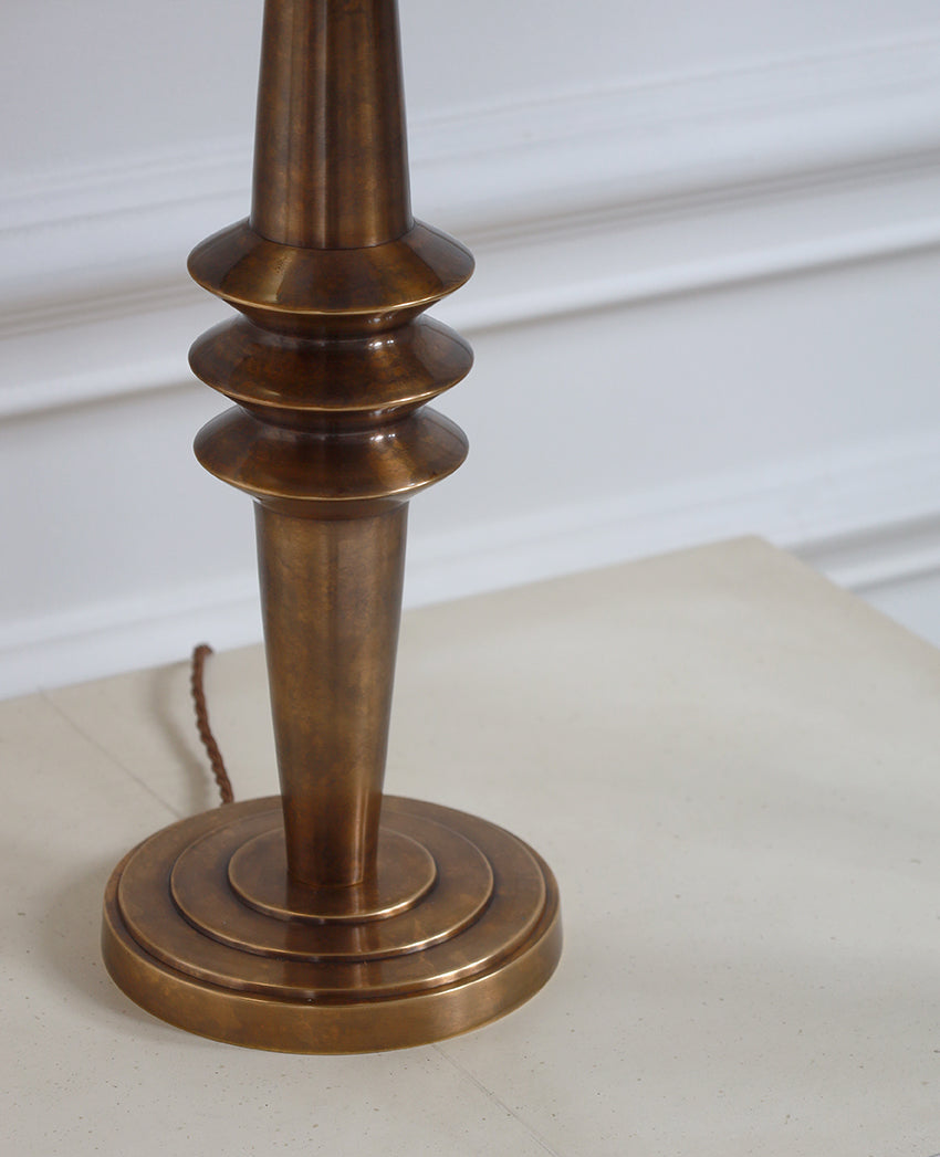 Close-up of a bronze lamp base on a white surface