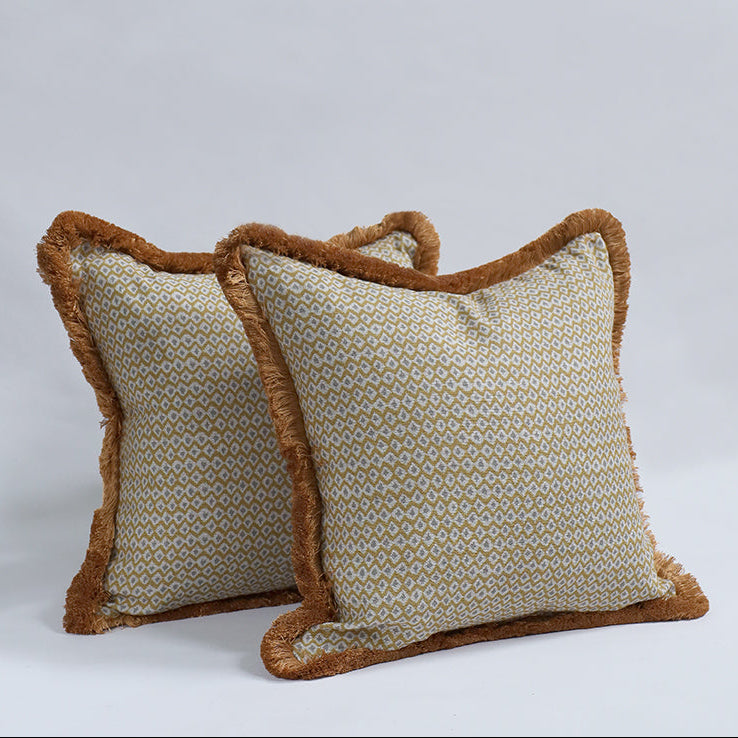 Two decorative pillows with brown trim on a light gray background