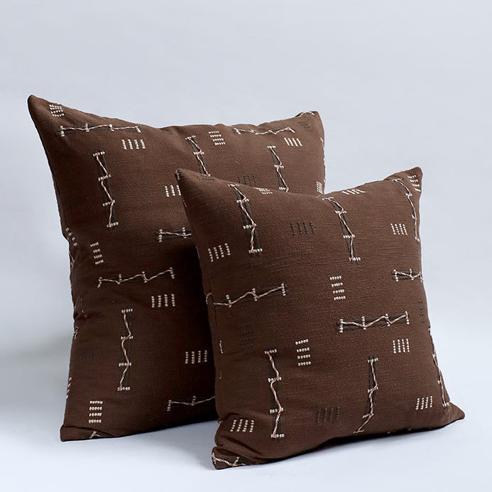 Two brown pillows with a subtle pattern on a light gray background