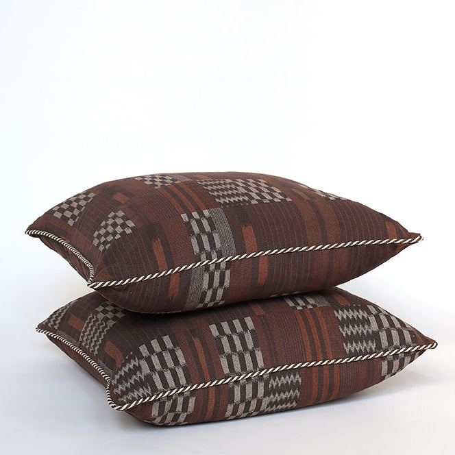 Two patterned pillows stacked on a white background