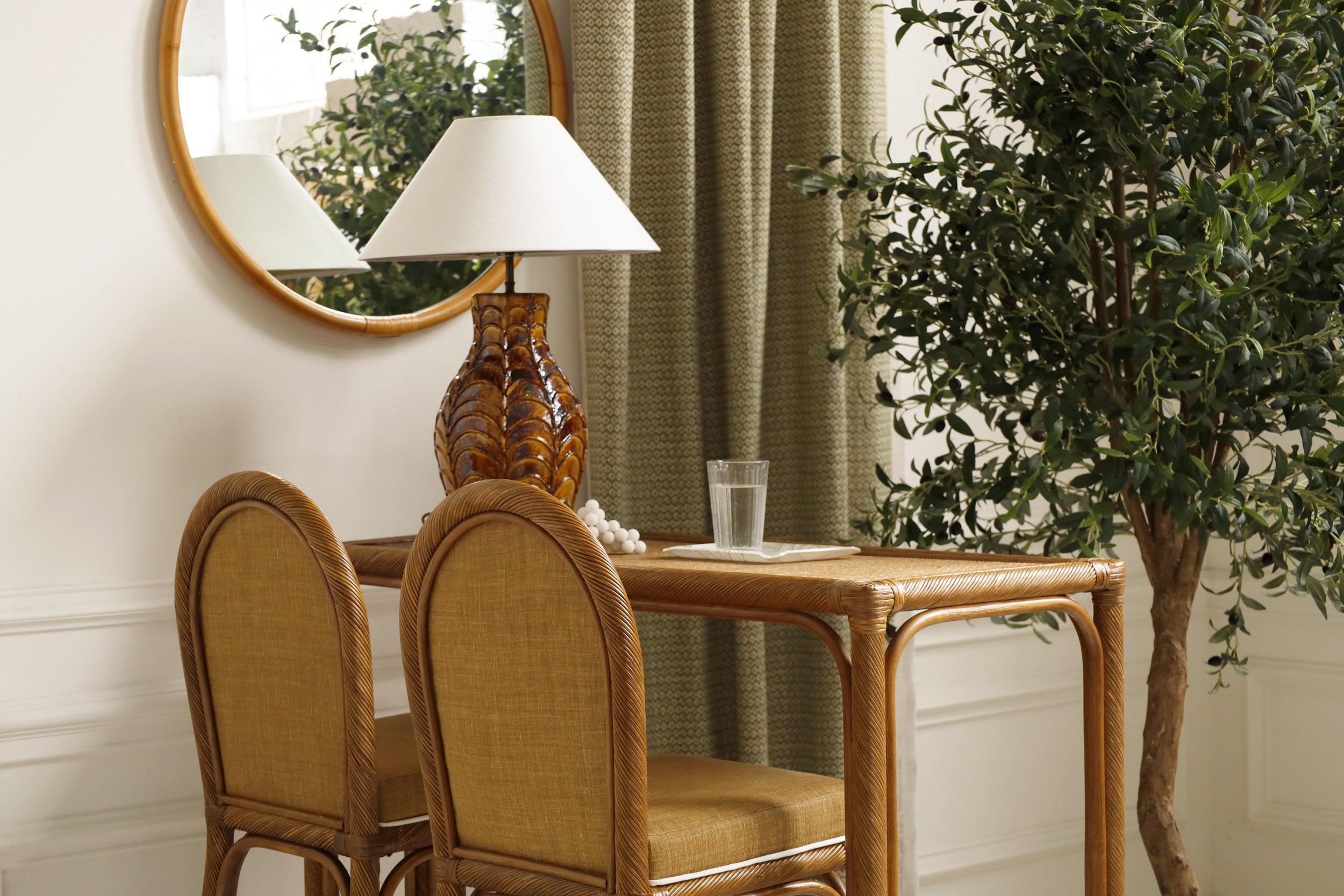 Dining area with wooden table and chairs, lamp, and potted plant.