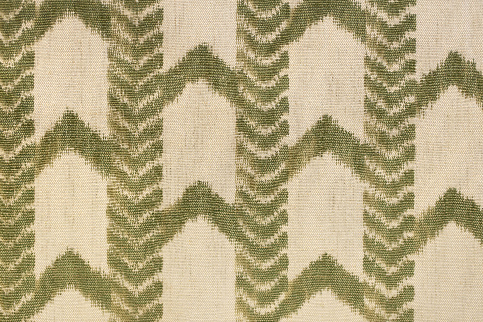 Close-up of a fabric with green zigzag pattern on beige background